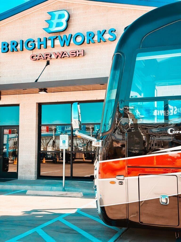 Brightworks Fort Worth exterior building sign with a Cornerstone motorcoach being serviced
