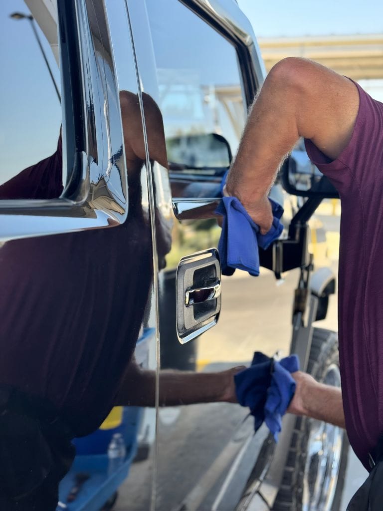 Brightworks Fort Worth detailer polishing a truck door handle with blue microfiber cloths