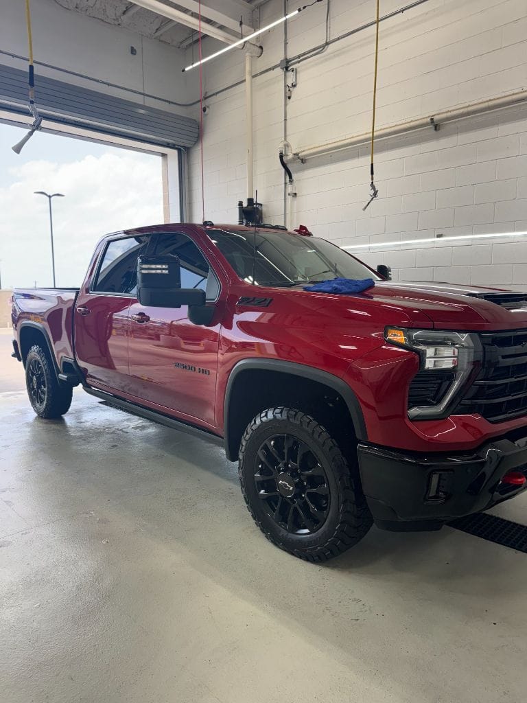 Red Chevy Silverado 2500 HD ZR2 full side profile showing a showroom-quality shine after detailing at Brightworks Fort Worth