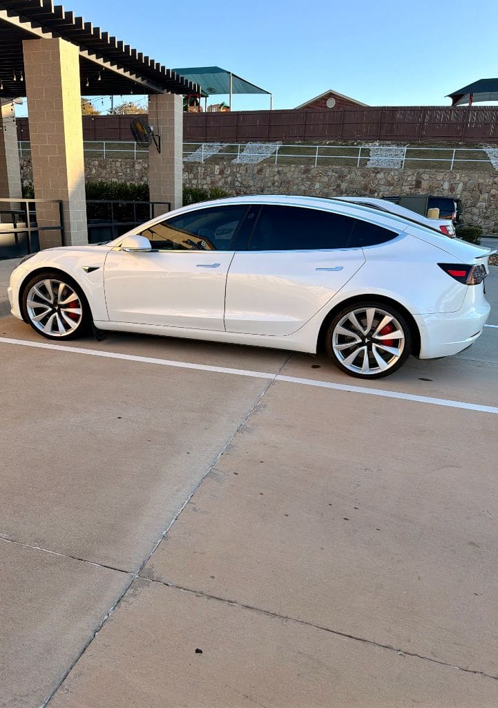 Freshly detailed white Tesla Model 3 parked under the Brightworks Fort Worth pergola after a full detail