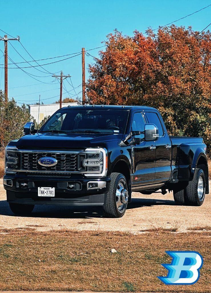Black Ford F-450 Super Duty dually truck looking pristine against fall foliage after a Brightworks Granbury detail — Brightworks logo watermark