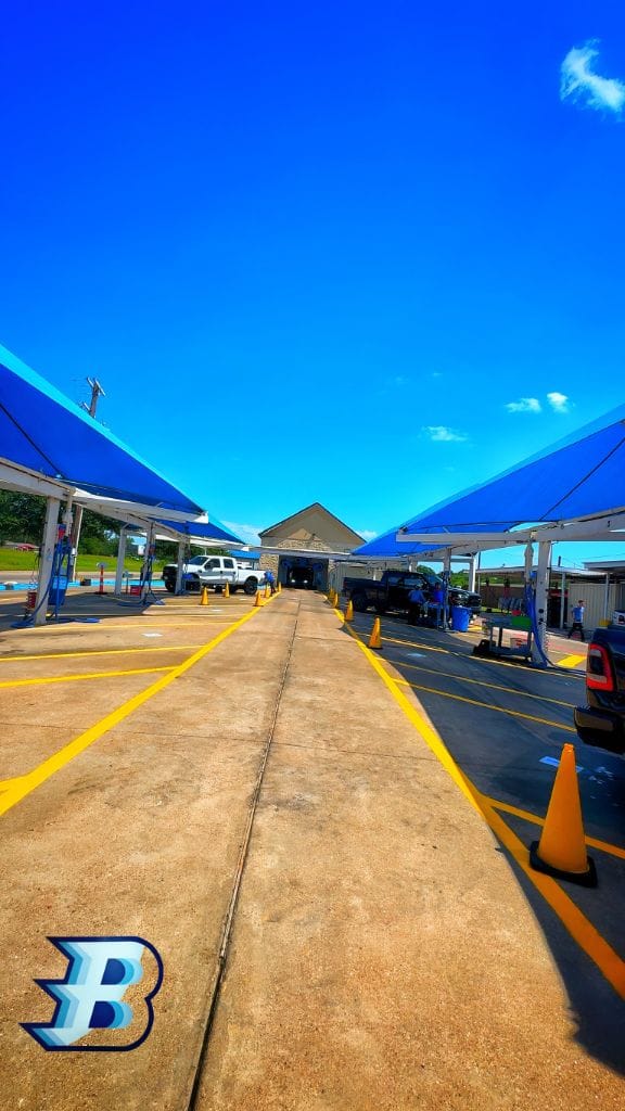 Brightworks Granbury — wide open detail lanes leading to the exterior wash entrance under blue canopies