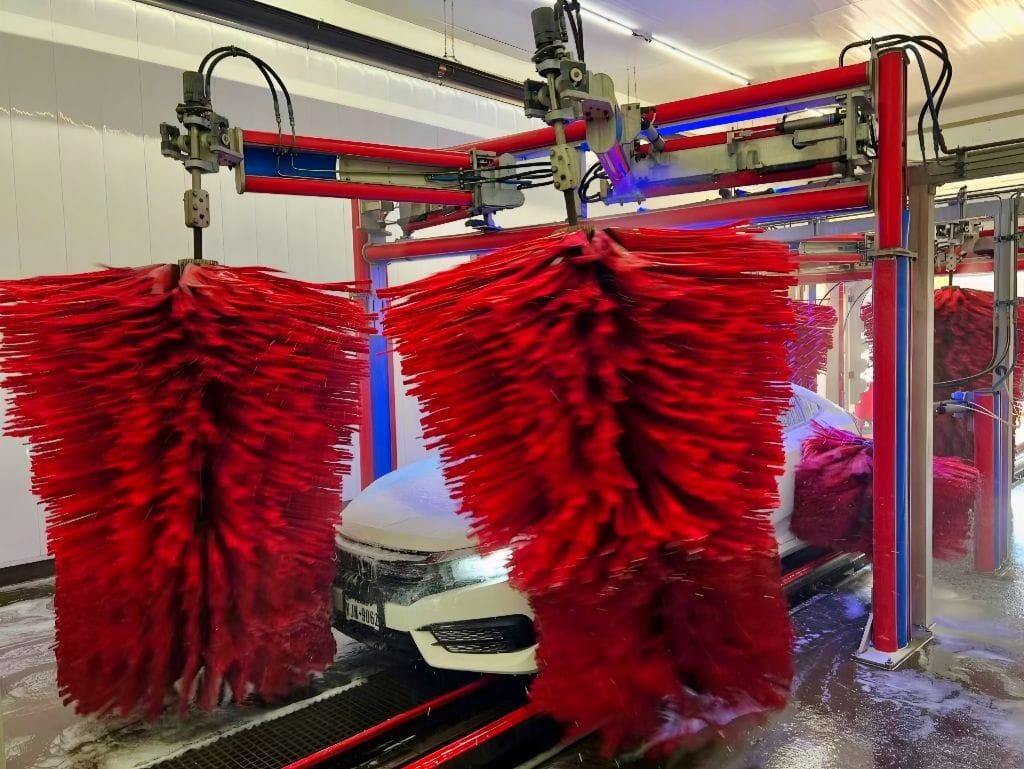 Brightworks Granbury exterior wash — full-size SUV being washed by dual red side brushes with blue LED accents