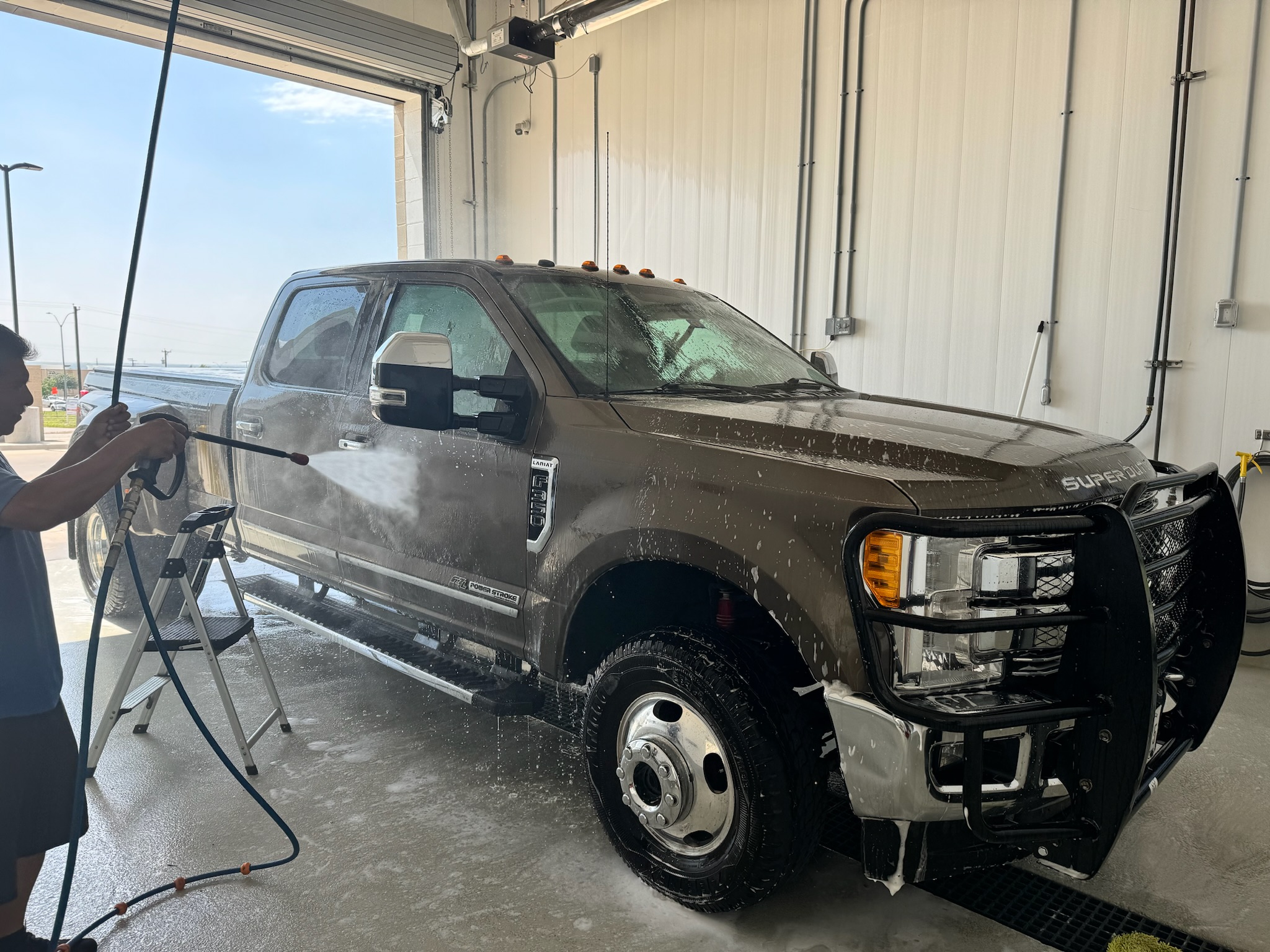 The Fort Worth team washing a pickup in an enclosed detailing bay.