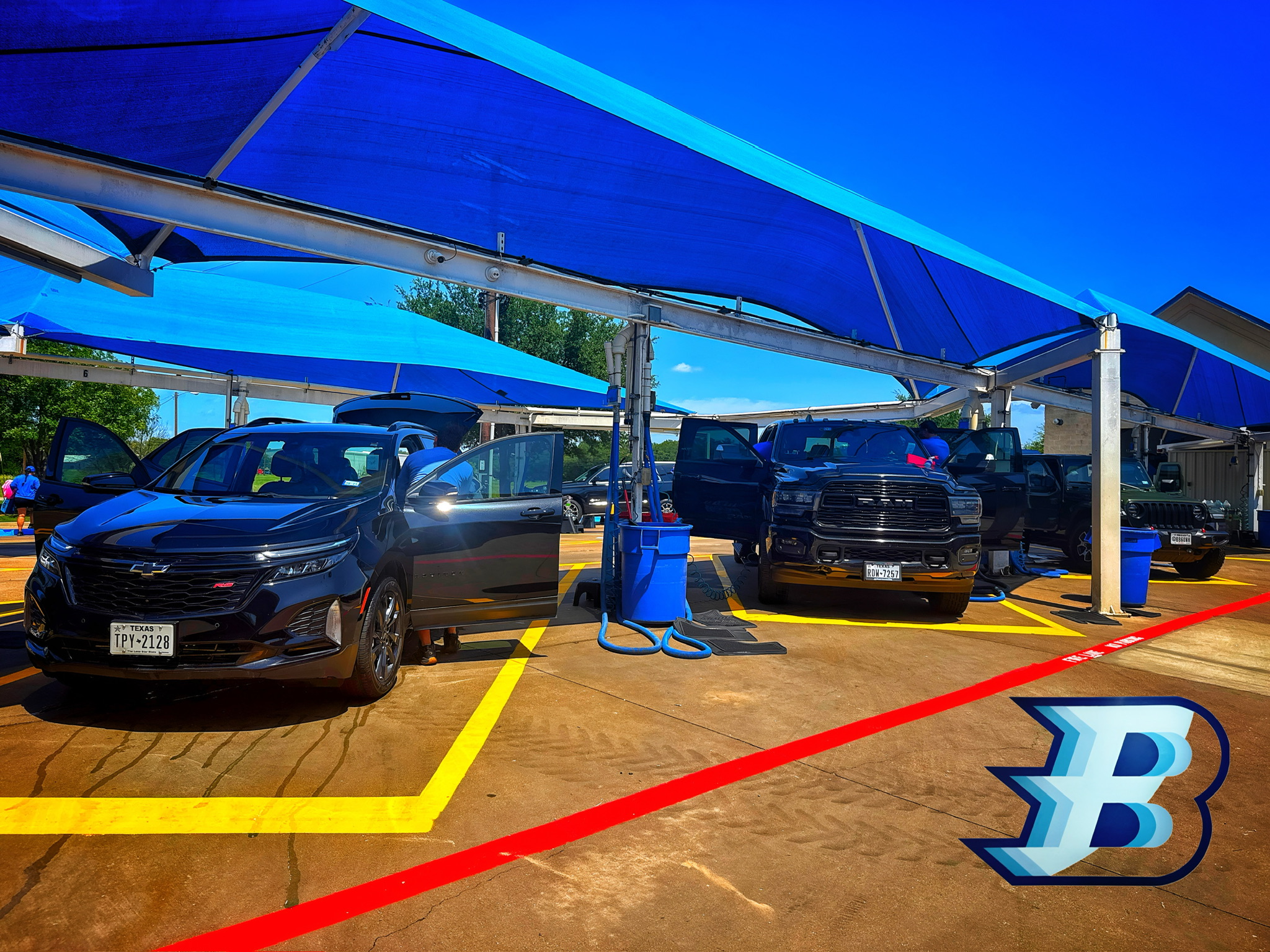 Vehicles beside the blue canopy at Brightworks Granbury.